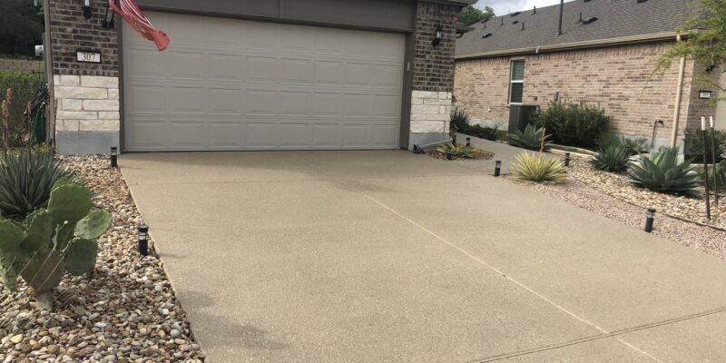 Result of driveway resurfacing on the background of garage doors.
