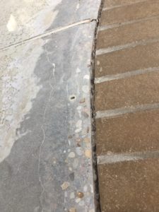 Closeup on a concrete patio coating in an Austin, TX home before repairing.