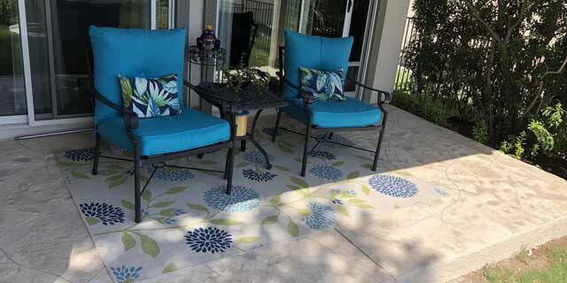 Tiled and refinished concrete patio with chairs on top, in a home in Austin, TX.