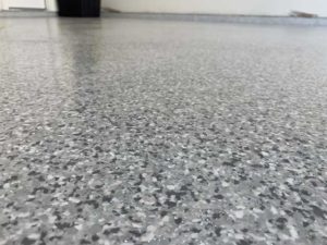 Grey, black, and white mosaic garage floor refinishing inside an Austin, TX home.