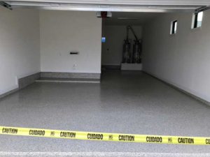 Space with safety tape after garage floor resurfacing by an Austin, TX contractor.
