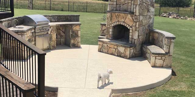 Luxury BBQ and firepalce on concrete patio flooring, resurfaced by Austin, TX leading contractor.
