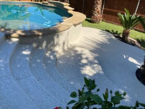 Pool patio resurfacing over steps outside an Austin, TX home under shade.
