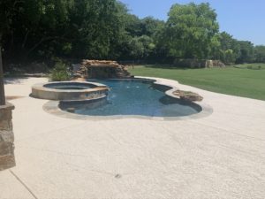 View from the patio on a backyard after complete pool deck refinishing by an Austin, TX contractor.