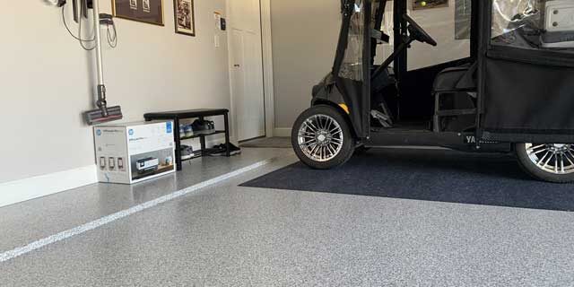Flooring done with commercial concrete floor coatings, a shoe rack, mini cart, and white walls.