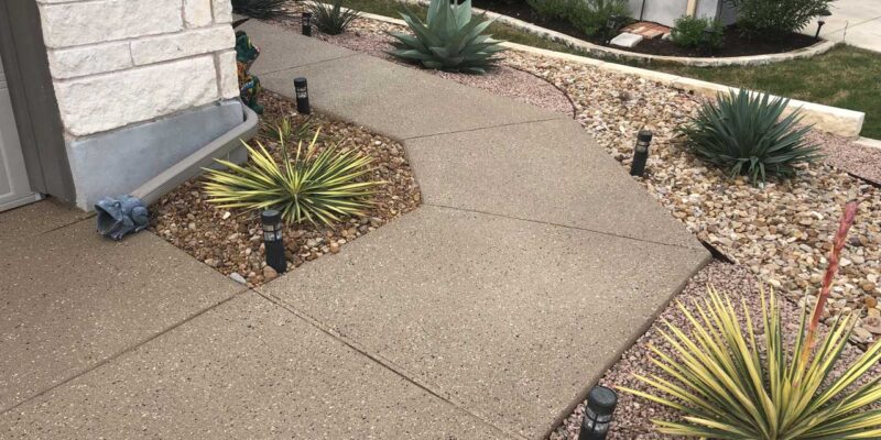 A decorative concrete walkway complemented by vibrant and beautiful desert plants