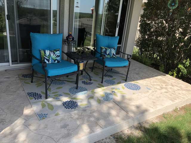 The sweet patio is crafted with a decorative concrete finish, combining charm with durability.